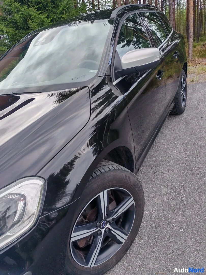 Etuviisto, nokka vasemmalle: Musta Volvo-katumaasturvaimu oikean sivun kolmasosassa, jossa näkyy etusuoja, takakulma ja pyörät. Auton väri on musta, joka on luettavissa korin pinna