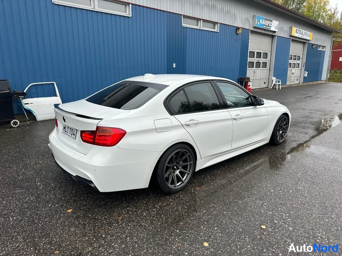 Takaviisto: Valkoisen BMW:n takakolmasosan kuva oikealta; rekisteritunnus ja takavalo näkyvissä.
