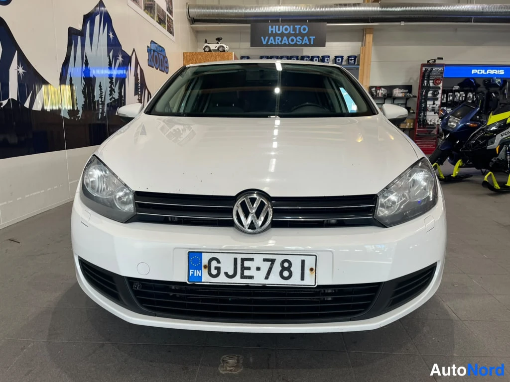 Edestä: Auton etupää suoraan edestä; etusäleikkö, Volkswagen-merkki, ajovalot ja rekisterikilpi.