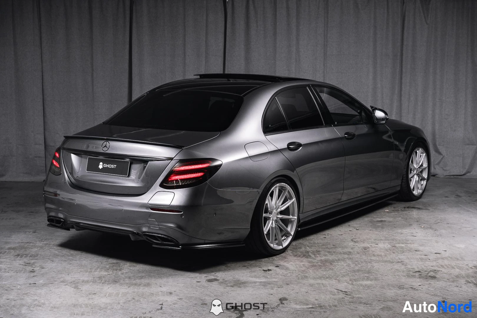 Takaviisto: Metallinvärisen Mercedes-Benz-sedan takaosa ja oikea kylki. Takavaloissa punainen valotyyppi.