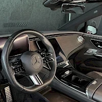 Ohjaamo: Ohjaamon lähikuva ohjauspyörällä, jossa Mercedes-Benz-logo sekä keskellä sijaitseva pystysuora kosketusscreensäinöintilaite.