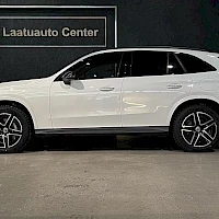 Sivulta: Valkoisen Mercedes-Benz GLC:n sivukuva vasemmalta; tummat kevytmetallivanteet, taustalla Laatuauto Center -kyltti.