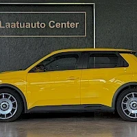 Sivulta: Keltainen pikkuauto sivusta kuvattuna: kylki näkyvässä ilman etu- tai takapäätä, taustalla Laatuauto Center -kyltti.