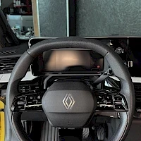 Ohjaamo: Ohjauspyörä, jossa Renault-logo keskellä, sekä digitaalinen mittaristo näyttöineen.