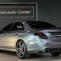 Takaviisto: Harmaan Mercedes-Benz-sedanin takakulmanäkymä; takavalot, spoileri ja kaksoispakoputket näkyvissä.