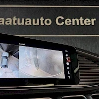 Ohjaamo: Car display shows camera image of road behind the vehicle in reverse gear (R). Text 'aatuauto Center' visible on glass above.