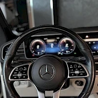 Muu: Mercedes-Benzin ohjauspyörä ja digitaalinen mittaristo lähikuvassa, keskellä ylhäällä infotainment-näyttö.