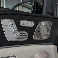 Yksityiskohta: Ovikohtainen kuva etuovesta. Näkyvillä on sähköinen penkinsäätöjärjestelmä, äänentoistolaitteisto ja Mercedes-Benz logo. Ovessa on myös painikkeita ikkunoiden h