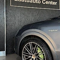 Sivulta: Sivukuva auton takapyörästä ja ovesta, ovessa e-hybrid-merkki.