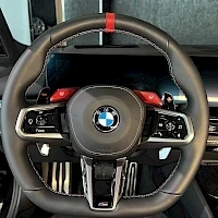 Yksityiskohta: BMW M-ohjauspyörä lähikuvassa: punainen keskusaikamerkki ylhäällä, punaiset M1- ja M2-napit sekä vaihdepaddelit rattien takana.