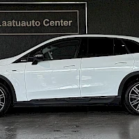 Sivulta: Valkoinen Mercedes-Benz EQE SUV sivusta kuvattuna autosalissa.