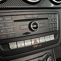 Yksityiskohta: Mercedes-Benzin keskconsole: radio, ilmastointi ja PARKTRONIC-parkkiassistentin kytkin