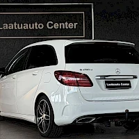 Takaviisto: Valkoisen Mercedes-Benz B 200:n takaviisto; takavalot, peräluukku ja Mercedes-tähti näkyvissä, perässä Laatuauto Center -teksti, tummat kevytmetallivanteet.