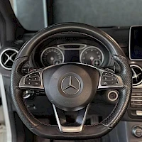 Etuistuimet: Ohjauspyörän läheiskuva. Ohjauspyörässä on Mercedes-Benz logo ja multifunktionapit molemmin puolin.