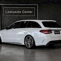 Takaviisto: Valkoinen Mercedes-Benz-farmari takakulmakuvassa; takavalot, takaluukku ja sivu näkyvät, taustalla Laatuauto Center -kyltti.