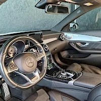 Muu: Auton ohjaamo näkyy kuvasta: Mercedes-merkillä varustettu ohjauspyörä, kojelauta, keskitaso ja infotainment-näyttö.