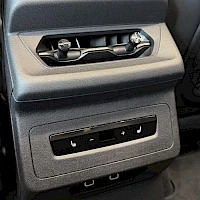 Etuviisto, nokka oikealle: Audi SQ6 e-tronin takaosan keskikäytävä: ilmastointiaukot, istuinlämmityspainikkeet ja kaksi USB-porttia.
