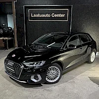Etuviisto, nokka vasemmalle: Musta Audi A3 Sportback etuviistöstä vasemmalta kuvattuna sisätiloissa, taustalla Laatuauto Center -kyltti.