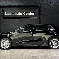 Sivulta: Musta Audi A3 Sportback sivulta kuvattuna sisätiloissa, taustalla Laatuauto Center -kyltti.