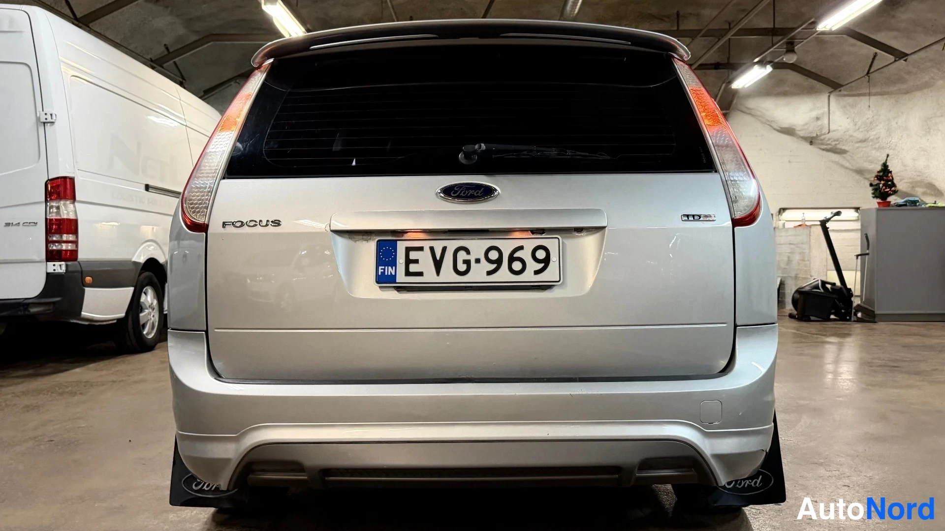 Takaa: Takakuvassa näkyy hopeanvärinen Ford Focus Farmari. Takavalot, rekisterikilpi ja 'FOCUS' sekä 'TDCi'-tekstit löytyvät takaluukusta.