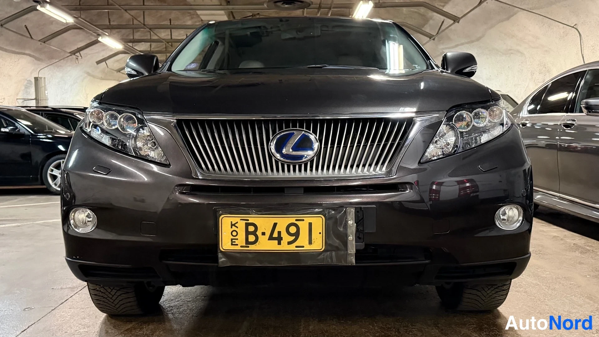 Edestä: Musta Lexus RX suoraan edestä, etusäleikkö ja rekisterikilpi KÖE B-491 näkyvät tarkasti.