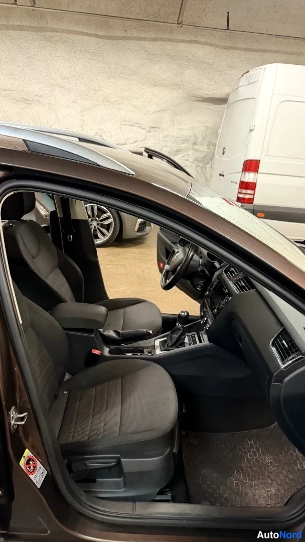 Muu: Avatun oven kautta näkyy autojen etupenkki ja kojelauta tummassa sisustassa.