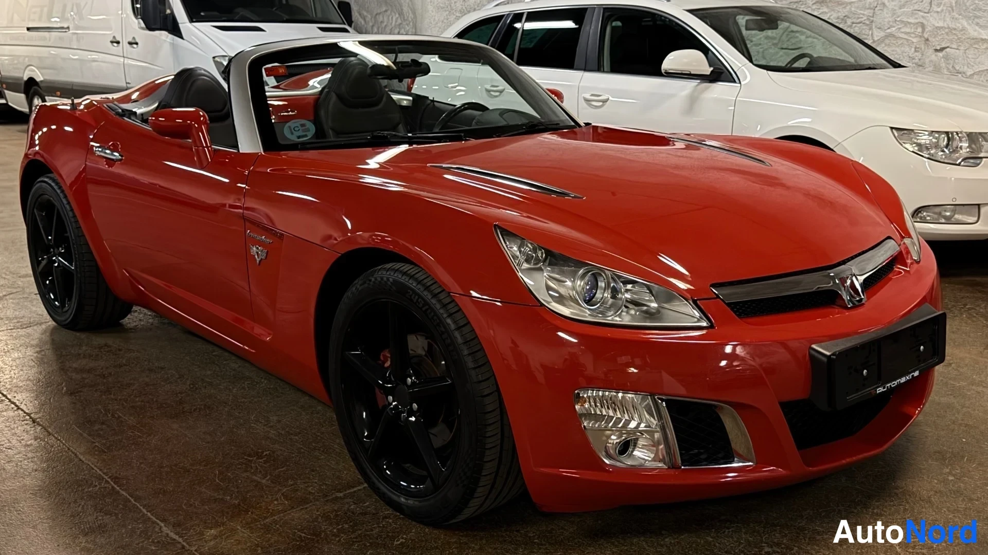 Etuviisto, nokka oikealle: Punainen Opel GT -avomusto kolmivartalo-asennossa edestä oikealta; etupää ja oikea kylki näkyvissä, mustat vanteet.