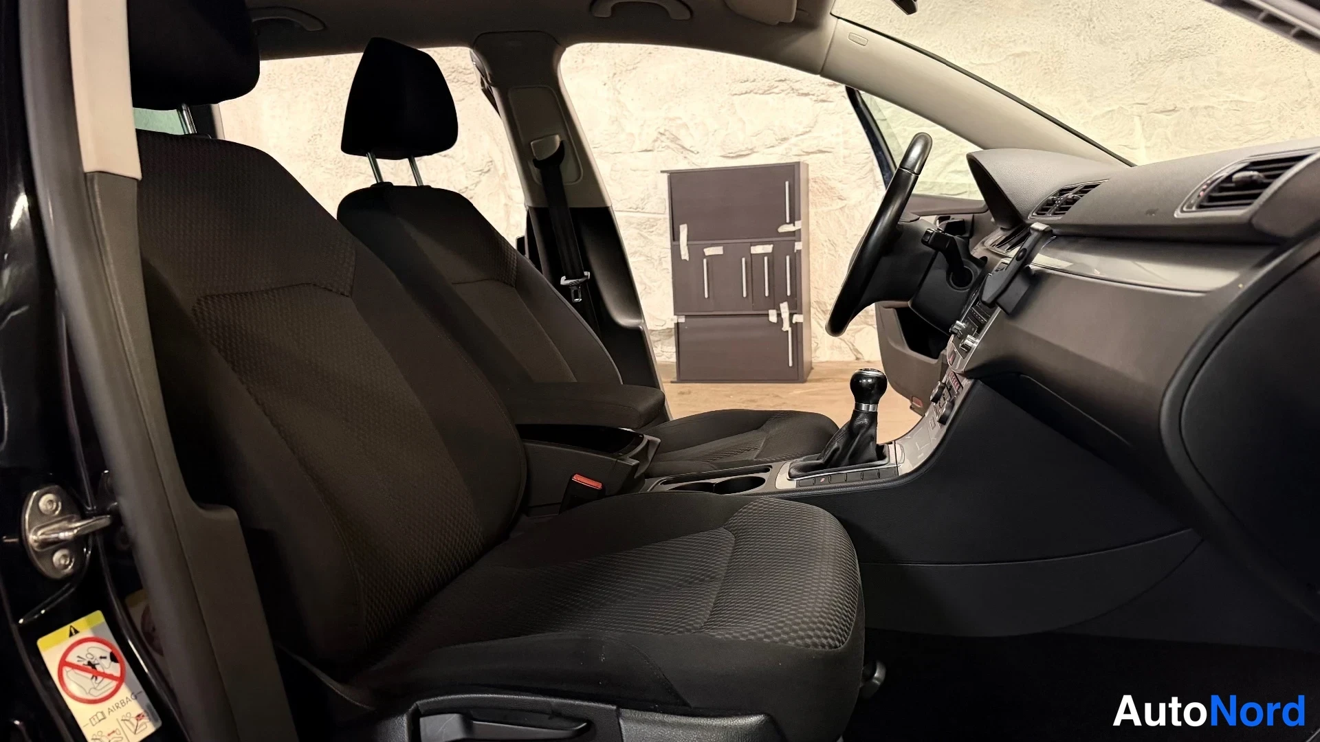 Etuistuimet: Full view of the front cabin interior with driver and front passenger seats visible along with steering wheel and dashboard.