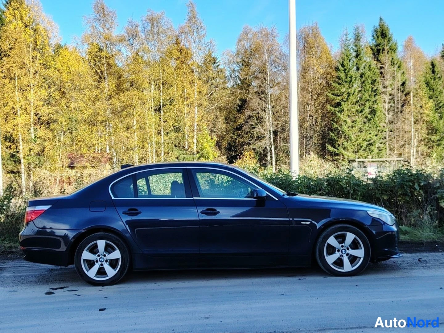 Takaviisto: Musta sedan sivulta, rekisterikilpi osittain näkyvissä.
