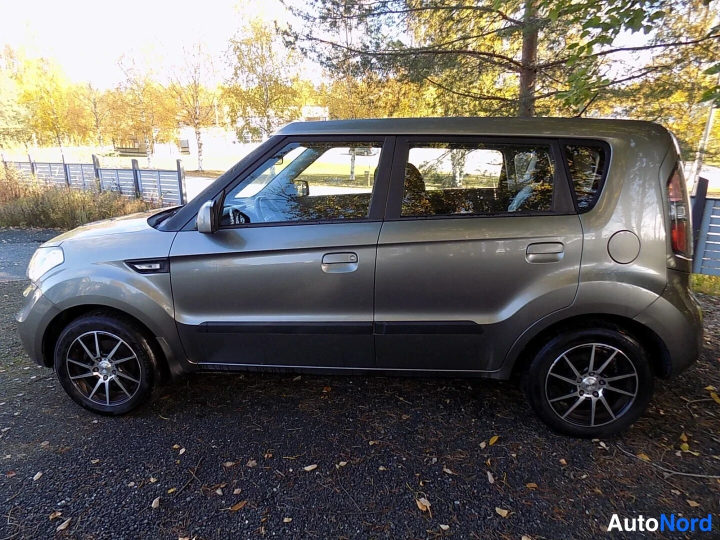 Sivulta: Kia Soul -henkilöauto harmaana täytenä sivunäkymänä vasemmalta katsottuna, kevytmetallivanteet näkyvissä.