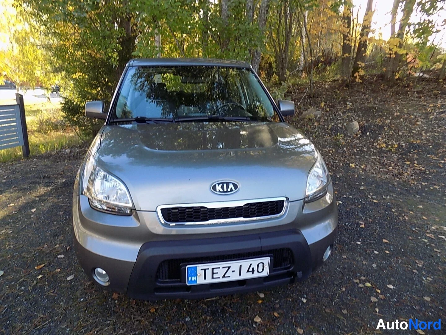 Edestä: Kia Soul suoraan edestä, Kia-merkki ja rekisterikilpi harmaalla keulalla.