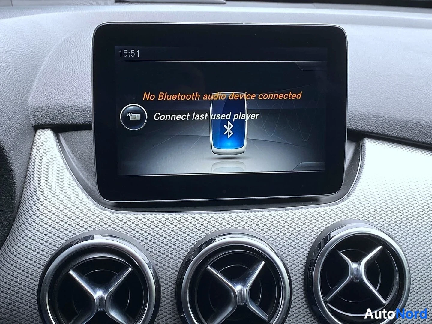 Muu: Kojelautaan kiinnitetty erillinen näyttö, jonka ruudulla lukee 'No Bluetooth audio device connected' ja 'Connect last used player'; kolme pyöreää ilmastointisuu