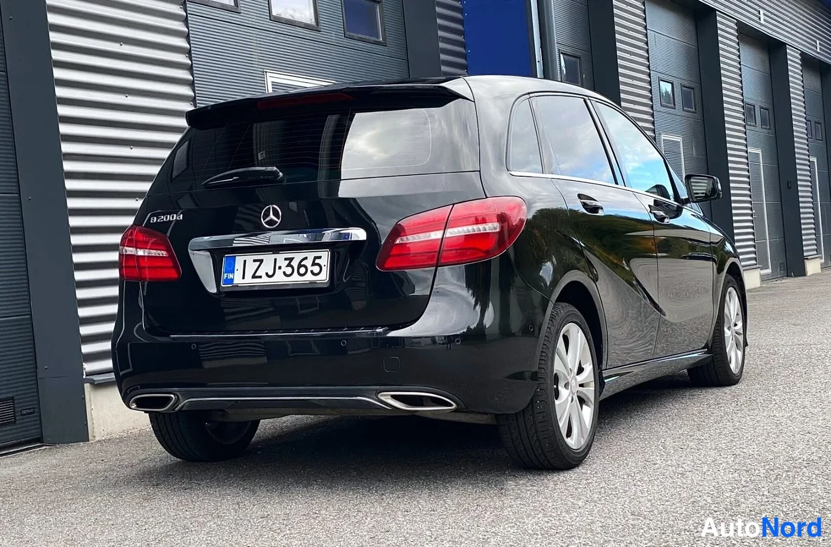 Takaviisto: Musta Mercedes-Benz B 200d takaapäin vasemmalta kolmannesnäkymässä, rekisterikilpi.