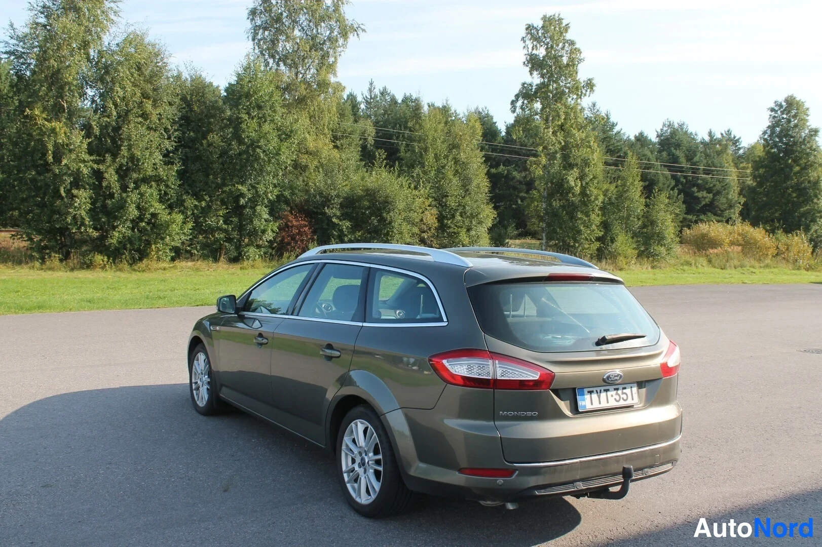 Takaviisto: Ford Mondeo -farmari takaa oikealta kolmivartalokuvassa, rekisterikilpi, hinauskoukku takapuskurissa.