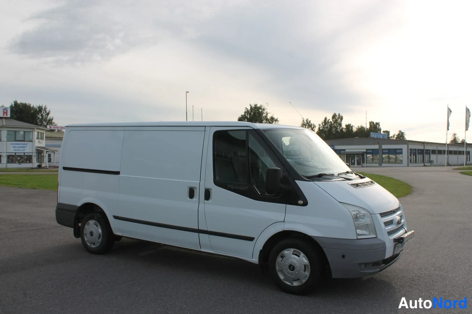 Etuviisto, nokka oikealle: Ford Transit -pakettiauton etukulmakuva oikealta, keulakulta ja konehuolto-ojen yläpuoli näkyvät.