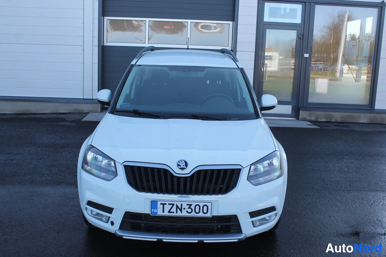 Edestä: Valkoisen Skoda Yetin etunäkymä, jäähdytinsäleikkö ja -rekisterikilpi keskeisellä, sumuvalot konepellin alla.