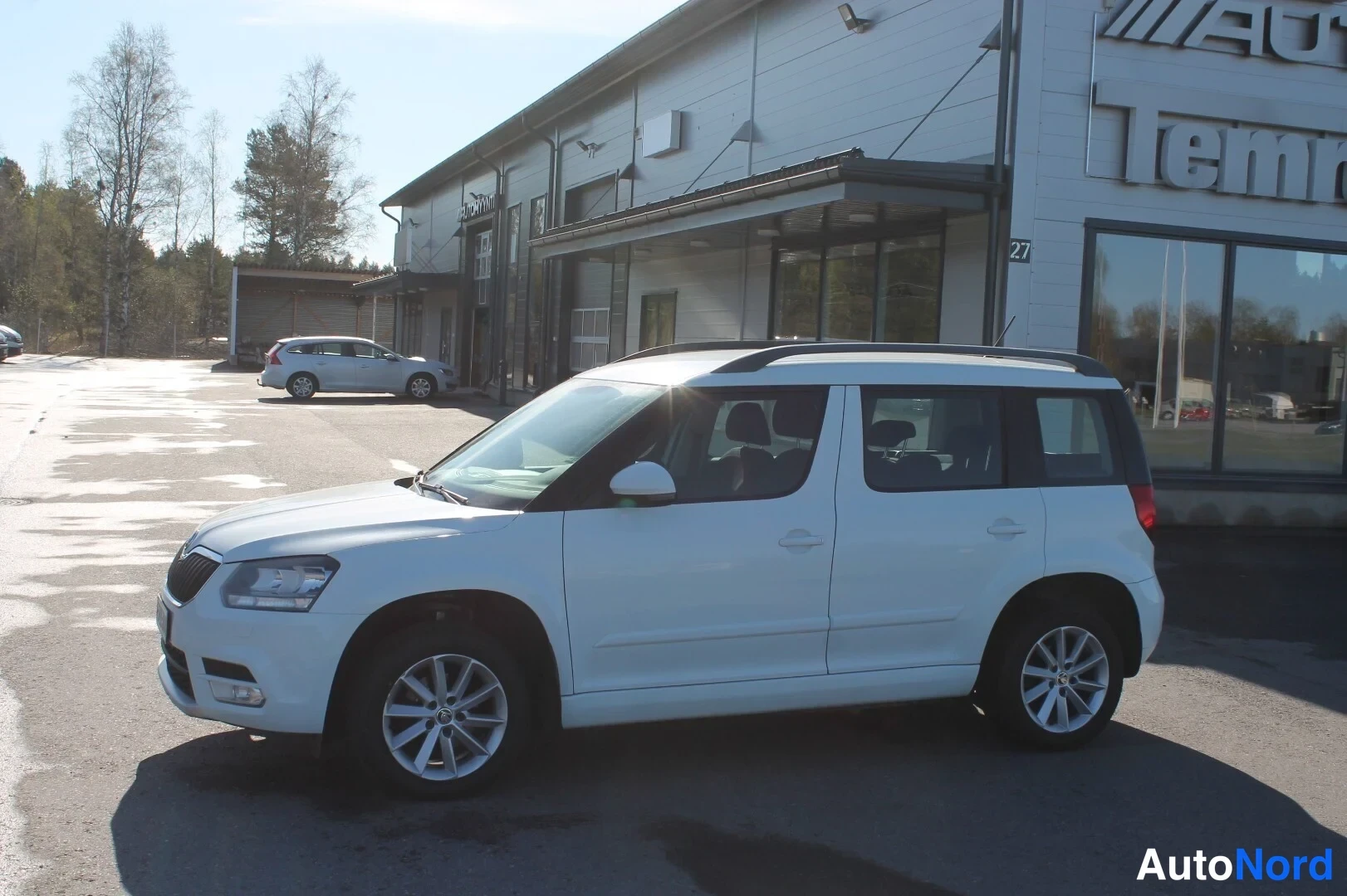 Etuviisto, nokka vasemmalle: Skoda Yeti sivukulmasta vasemmalta, valkoinen kori, kattokaiteet näkyvissä.