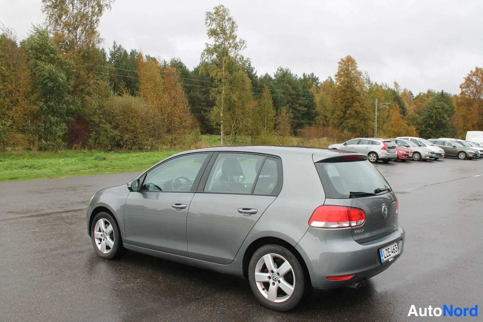 Takaviisto: Harmaa Volkswagen Golf takakulmasta parkkipaikalla, rekisterikilpi.
