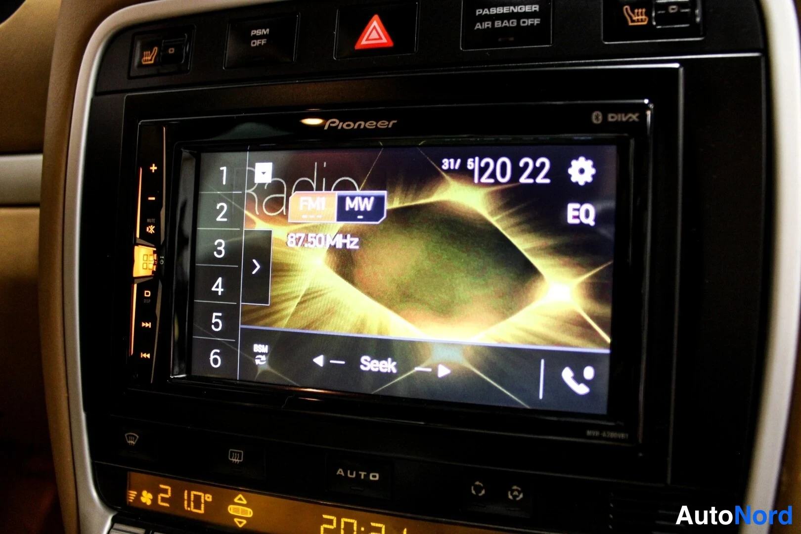 Yksityiskohta: Kojelaudan Pioneer-radio näyttää FM-radiota taajuudella 87.50 MHz; ylhäällä PSM OFF- ja PASSENGER AIR BAG OFF-merkkivalot sekä varoitusmerkki.