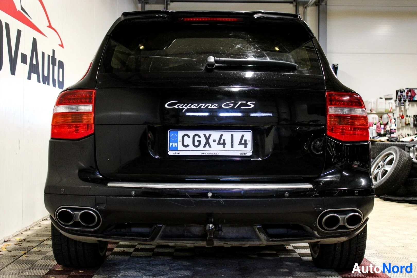Takaa: Mustan Porsche Cayenne GTS:n takapää, rekisterikilpi, neljä pakoputkea ja hinauslaiha