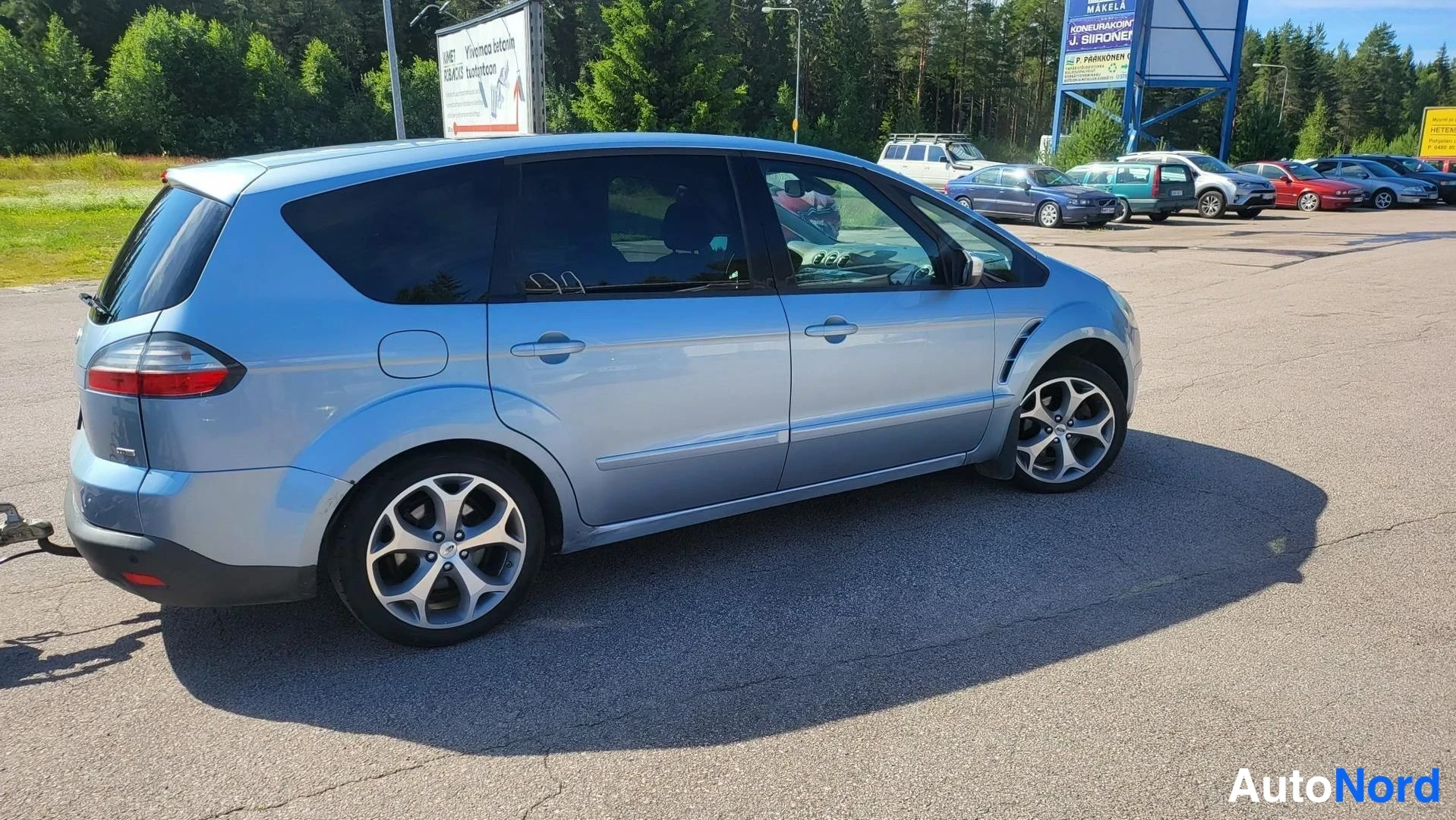 Takaviisto: Vaaleansinisen Ford S-MAX:n takaosa ja kylki valokuvattuna lukkoja puolelta.