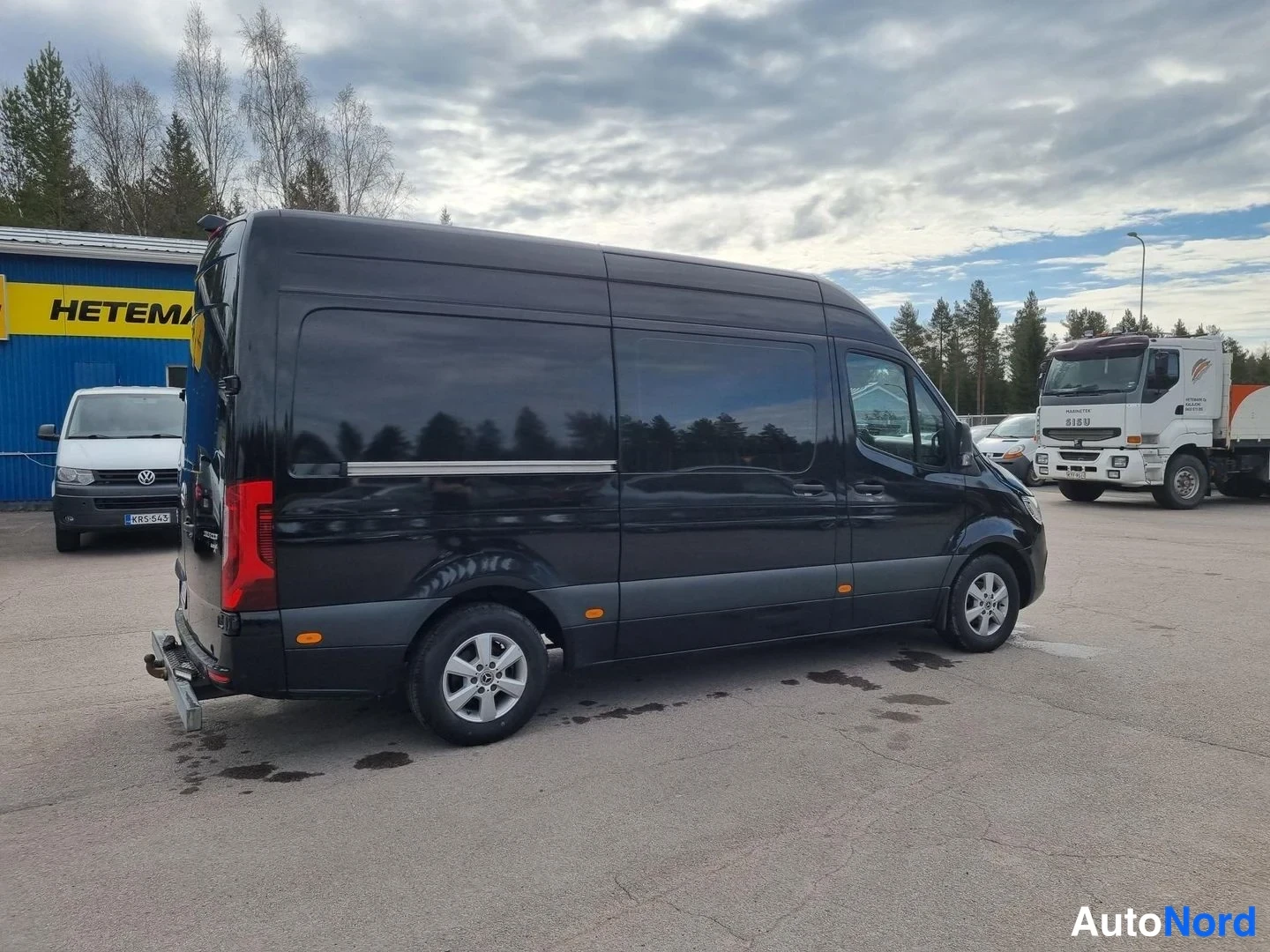 Takaviisto: Mustan Mercedes-Benz Sprinter -pakettiauton takakolmasosan kuva vasemmalta puolelta, takaovi ja kylki näkyvät.