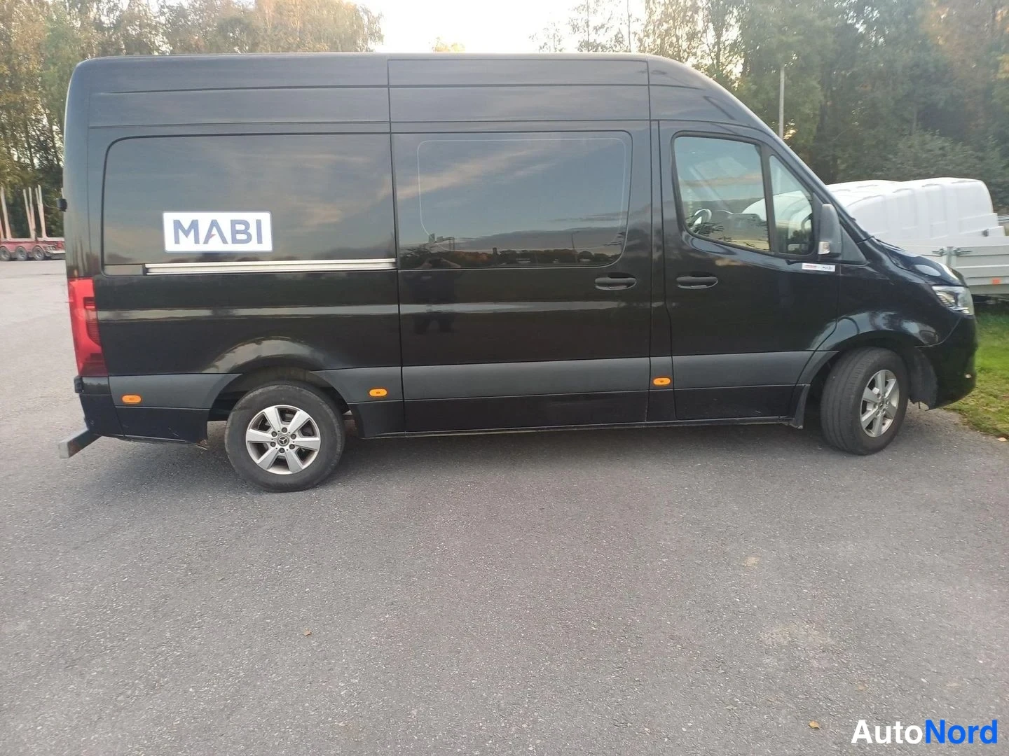 Sivulta: Mustan Mercedes Sprinter -pakettiauton sivukuva vasemmalta; sivussa MABI-logokyltti.