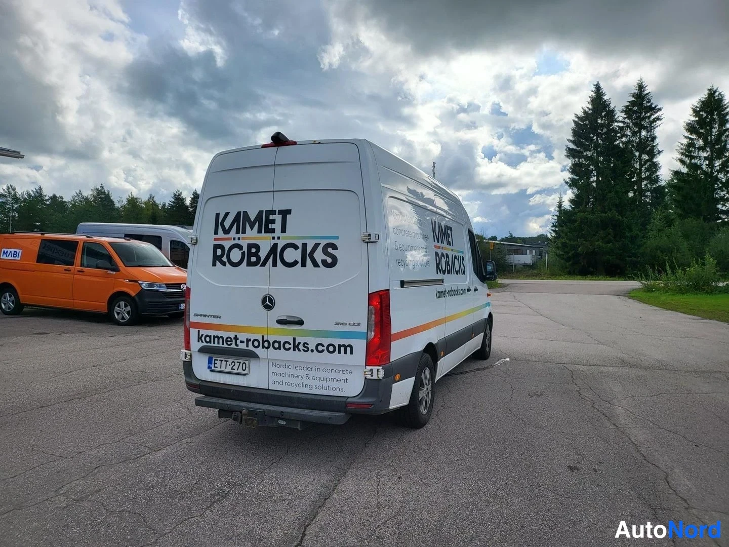 Takaviisto: Mercedes-Benz Sprinter -pakettiauto takaa vinosta oikealta, valkoinen koristettuna KAMET RÖBÄCKS -tekstillä