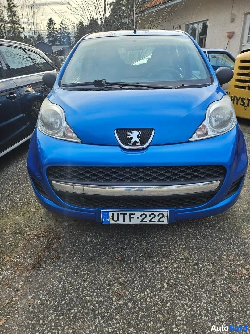 Edestä: Sinisen Peugeot 107:n keula suoraan edestä, rekisterikilpi.