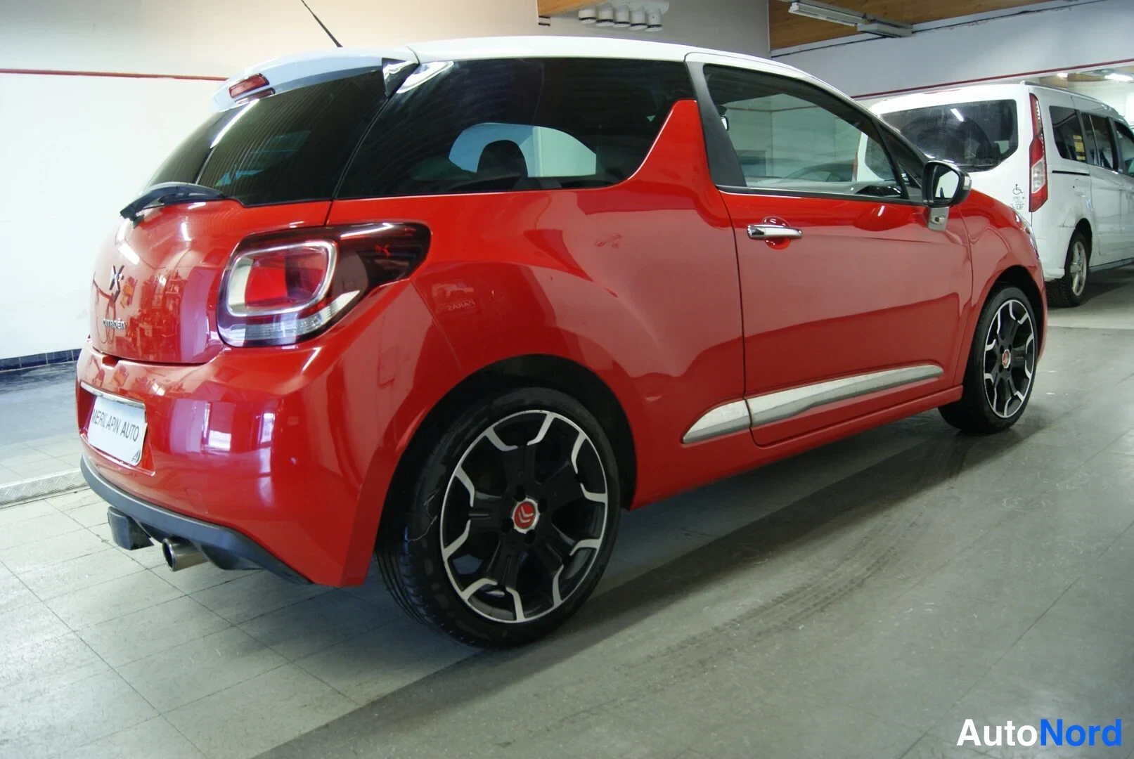 Takaviisto: Punaisen Citroën DS3:n takakulma, takavalot ja mustat vanteet näkyvissä.