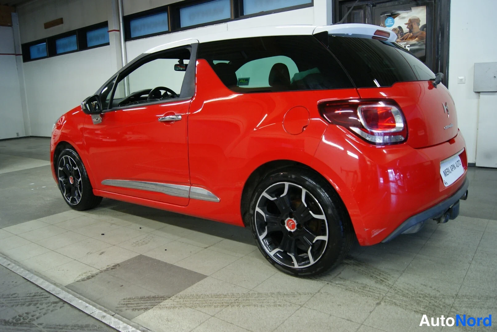 Takaviisto: Punaisen Citroën DS3:n takakulma, takavalot, Citroën-merkki ja mustat vanteet näkyvissä.