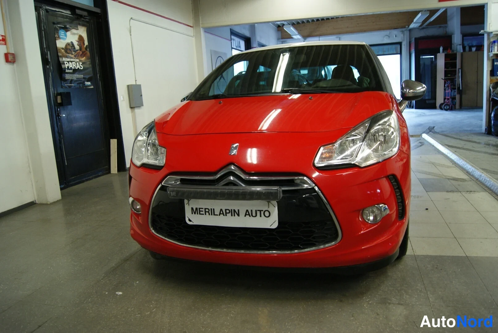 Edestä: Punaisen Citroënin keula kuvattuna suoraan edestä sisätiloissa.