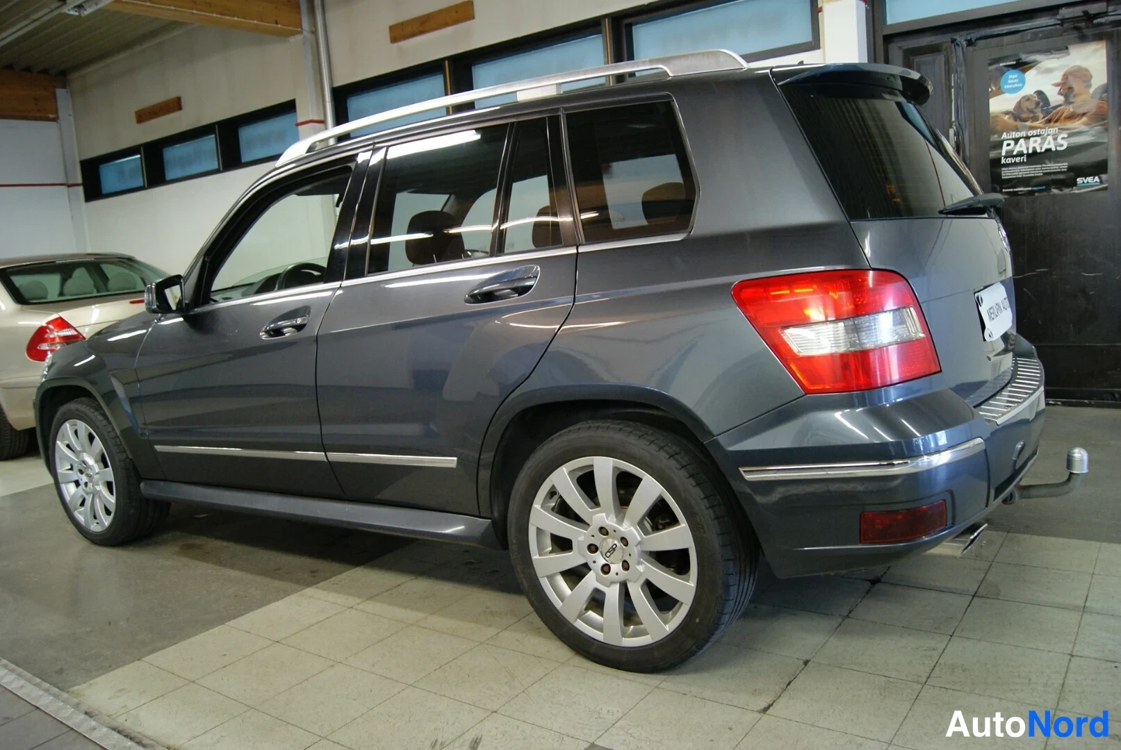Takaviisto: Tummanharmaan Mercedes-Benz GLK:n taka-ja-kylki-näkemä, vasen kylki ja takavalot näkyvissä.
