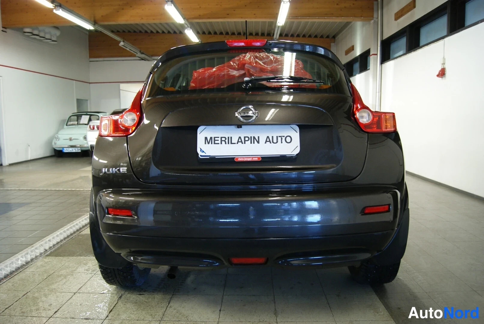Takaa: Nissan Juken takaosa suoraan takaa, JUKE-merkki ja takavalot näkyvissä.